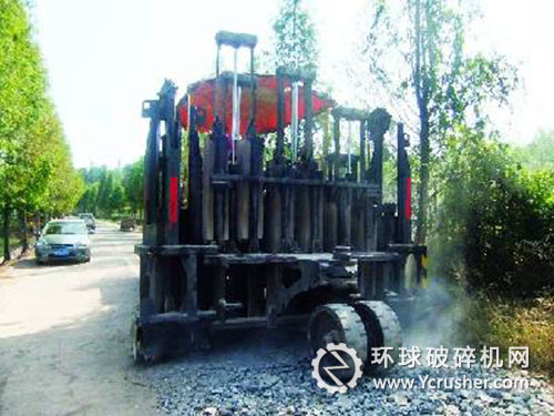 一臺(tái)大型多錘頭路面破碎機(jī)正在破碎水泥路面